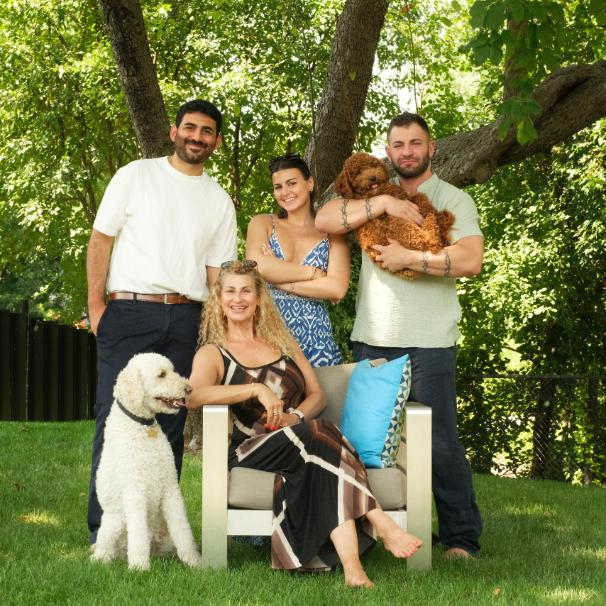 Group of four people with two dogs in a park setting