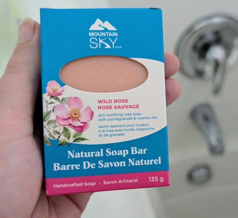 Hand holding a box of Mountain Sky Wild Rose Natural Soap Bar with a floral design.