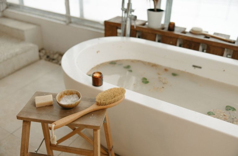 Bathroom scene with a bathtub, wooden stool, and bath accessories.
